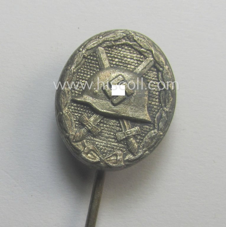 Complete, silver-class wound-badge- (or: 'Verwundeten-Abzeichen in Silber'-) set comprising of a maker- (ie. '65'-) marked example (and miniature!) as produced by the 'Hersteller' ie. maker: 'Klein u. Quenzer'