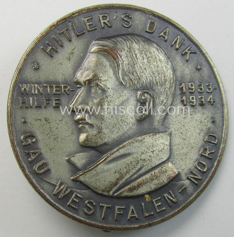 Commemorative, silvered 'Buntmetall'-based N.S.D.A.P.- (ie. WHW-) related 'tinnie' being a maker- (ie. 'Paulmann u. Crone'-) marked example depicting Adolf Hitler and showing the text: 'Hitler's Dank - Winterhilfe 1933-1934 - Gau Westfalen-No...