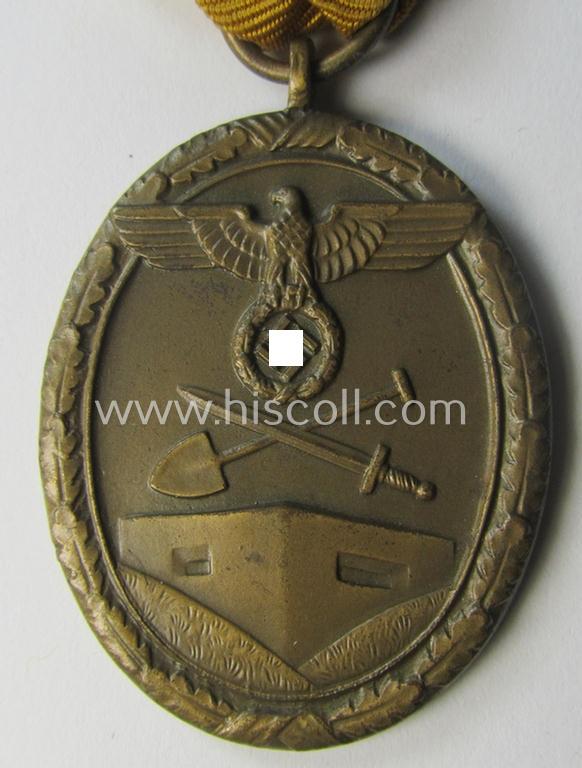 Medal-set: 'Deutsches Schutzwall Ehrenzeichen' (aka: 'Westwall'-medal) being a non-maker-marked- and/or: 'Buntmetall'-based specimen that comes mounted onto its period- (and neatly folded ie. pre-confectioned) ribbon (ie. 'Bandabschnitt')
