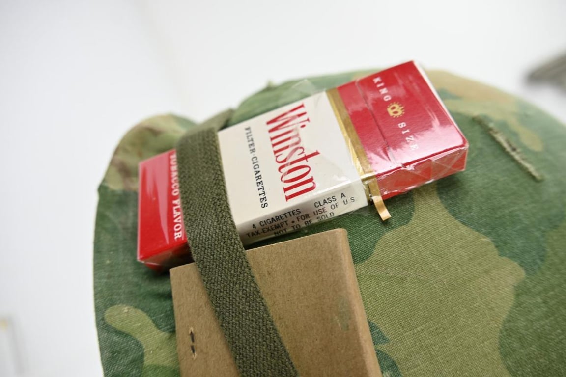 US Vietnam War Infantry helmet with camouflage cover and attached content