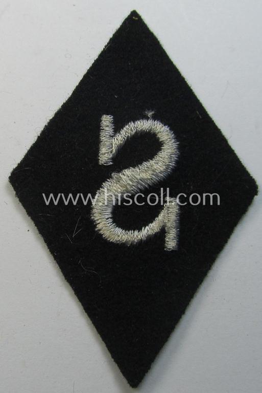 Rarely found Waffen-SS-pattern, machine-embroidered and black-coloured sleeve-insignia (ie. 'Ärmelraute') depicting a captital: 'S'-character as was used to signify the function of: 'Schirrmeister' within the: 'Waffen-SS'