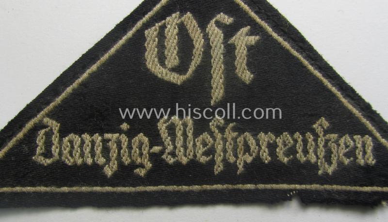 Extremely rarely encountered, 'HJ' ('Hitlerjugend') ie. 'BDM'- ('Bund Deutscher Mädel') district-triangle (ie. 'Gebietsdreieck') entitled: 'Ost Danzig-Westpreussen' being a truly worn- ie. used specimen that misses its 'RzM'-etiket