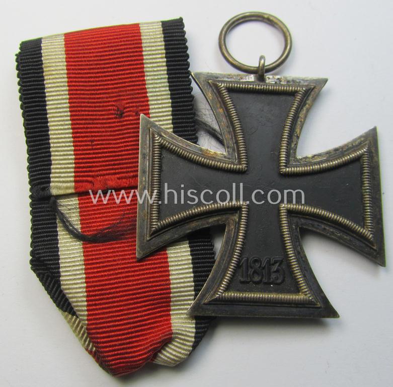 'Eisernes Kreuz II. Klasse' being a non-maker-marked example that comes together with its original- and once-mounted ribbon (ie. 'Bandabschnitt') as was produced by a (by me) unidentified maker (ie. 'Hersteller')