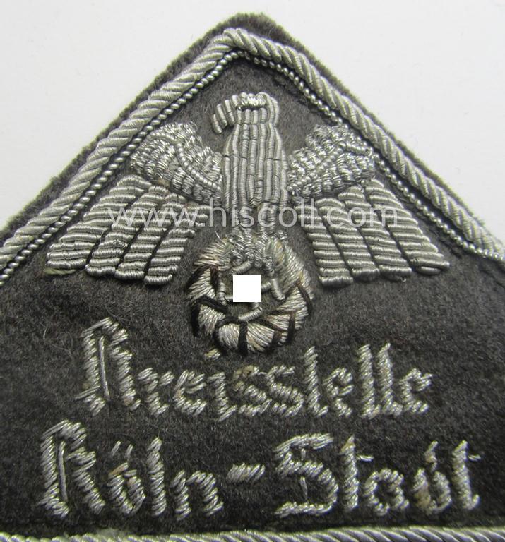 German Red Cross (ie. 'Deutsches Rotes Kreuz' or 'DRK') greyish-coloured- and/or triangular-shaped and neatly hand-embroidered (ie. typically officers'-pattern!) arm-eagle entitled: 'Kreisstelle Köln-Stadt'