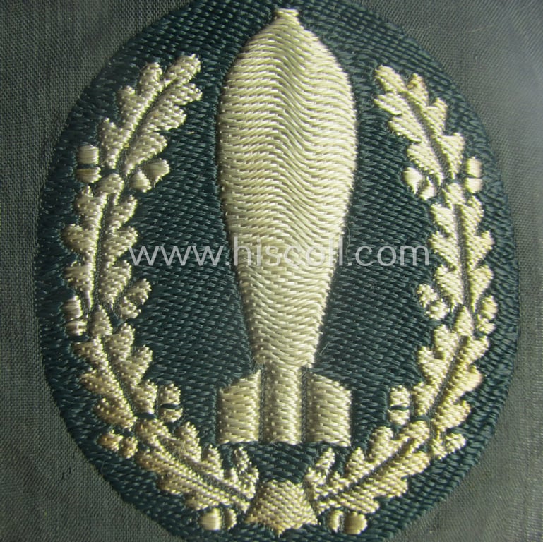 'BeVo'-woven version of a WH (Heeres) so-called: trade- and/or special-career insignia as intended for a: 'Nebelwerfer Richtkannonier' (or: qualified smoke-troops canon-operator)