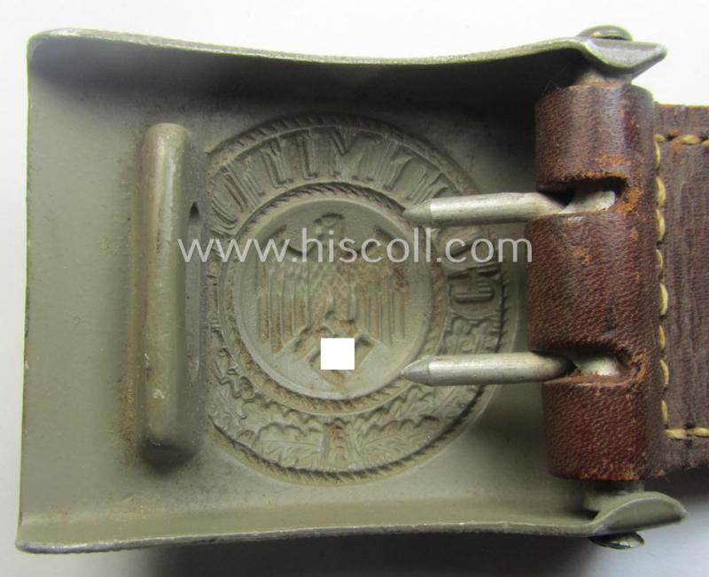 WH (Heeres) 'standard-pattern', field-grey-toned- and aluminium-based belt-buckle being a maker- (ie. 'E. Schneider - Lüdenscheid'-) marked- and/or: '1938'-dated example that comes mounted onto its leather-based tab