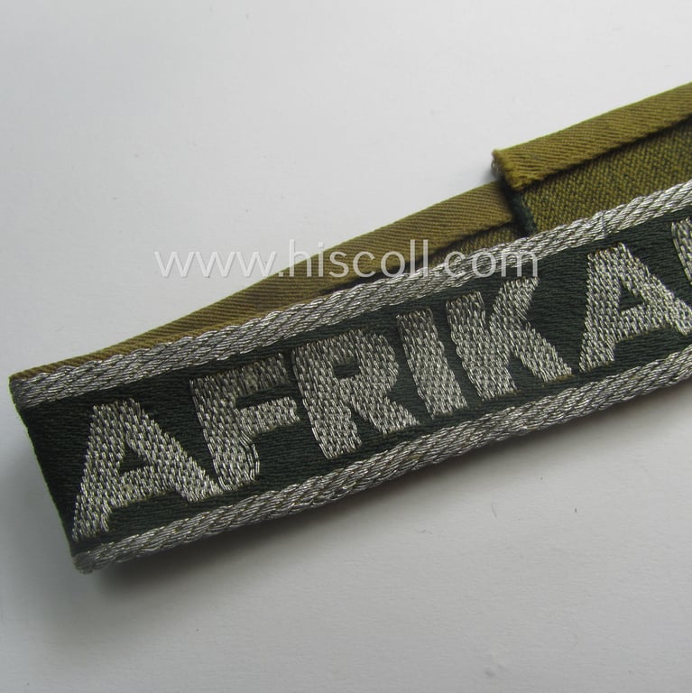 Truly worn, 'BeVo'-like cuff-title (ie. 'Ärmelstreifen') entitled: 'Afrikakorps' being a with certainty issued example that comes in an overall nice- (ie. once tunic-attached-), condition
