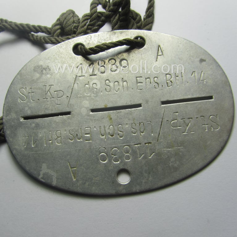 Neat, aluminium-based WH (Heeres) ID-disc (ie. 'Erkennungsmarke') bearing the clearly stamped unit-designation: 'St.Kp./Lds.Schtz.Ers.Btl. 14' (being a disc as intended for a soldier that served within the: 'Landesschützen-Ersatz-Battailon 14')