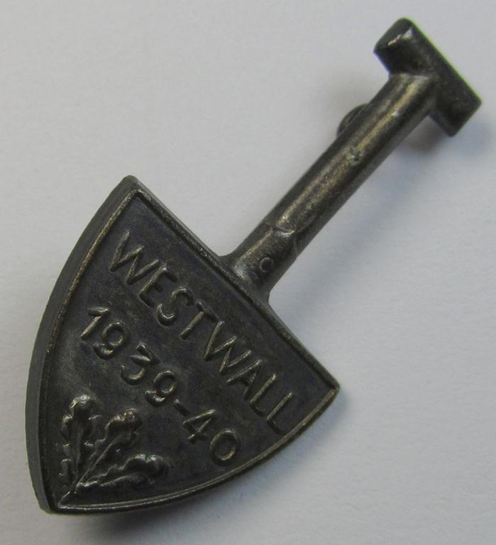 Neat, silver-toned, commemorative- and typical zinc- (ie. tin-) based day-badge (ie. 'tinnie') that comes in the format of a spade and depicting the text: 'Westwall 1939-40'
