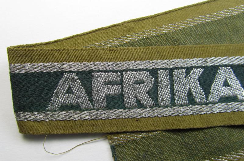 Superb, 'BeVo'-like cuff-title (ie. 'Ärmelstreifen') entitled: 'Afrikakorps' being a with certainty issued and truly worn example that comes in an overall nice- (ie. non-shortened- and most certainly once tunic-attached-), condition
