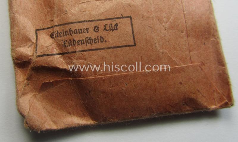 'Kriegsverdienstmedaille 1939'-set comprising of a non-maker-marked- (and/or: typical 'Buntmetall'-based!) specimen that came together with its period-ribbon and 'Zellstoff'-based pouch by the maker: 'Steinhauer & Lück'