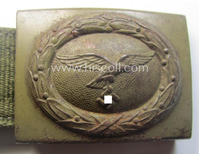 Rarely found WH (Luftwaffe) 'tropical-issued' belt-buckle being a non-maker-marked, beige-tan-coloured example that comes mounted onto its original, greenish-coloured- (and/or: 'webbing'-based-) tab