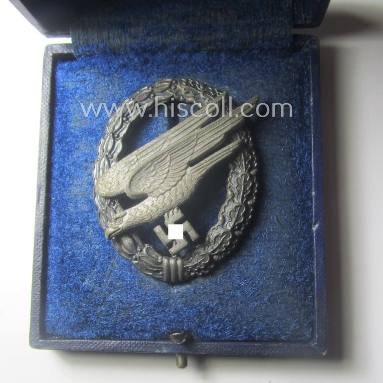Superb, WH (Luftwaffe) 'Fallschirmschützen-Abzeichen' being a (typical and clearly!) maker- (ie. 'A'-) marked and 'Feinzink'-based example by the: 'Assmann & Söhne'-company that comes stored in its period etui