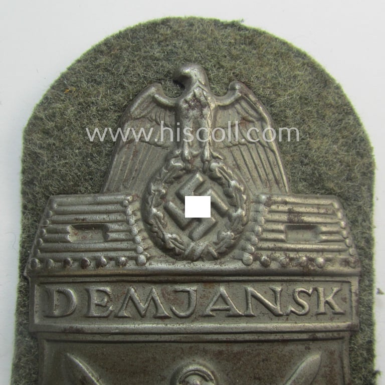 WH (Heeres ie. Waffen-SS) 'Demjansk'-campaign-shield (of the 'missing log'-pattern) as executed in typical magnetic metal (ie. so-called: 'Eisenblech') and that comes in an overall very nice- ie. fully untouched, condition