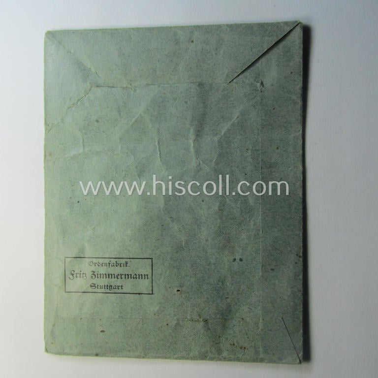 Medal-pouch entitled: 'Eisernes Kreuz 2. Klasse 1939' being a (typical) bluish-coloured example as executed in: 'Zellstoff'-based paper as was produced by the maker- (ie. 'Hersteller'): 'Ordenfabrik Fritz Zimmermann'