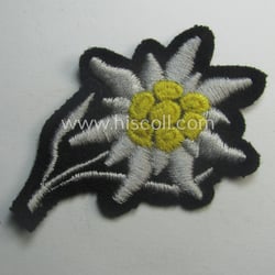 Waffen-SS-pattern, black-coloured M43-cap-insignia (ie. 'Mützenabzeichen') depicting an: 'Edelweiss'-flower...