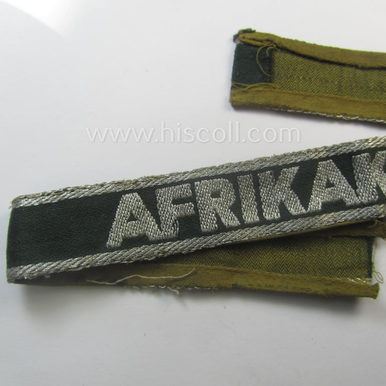 Truly worn, 'BeVo'-like cuff-title (ie. 'Ärmelstreifen') entitled: 'Afrikakorps' being a with certainty issued example that comes in an overall very nice- (ie. non-shortened- and/or once tunic-attached-), condition