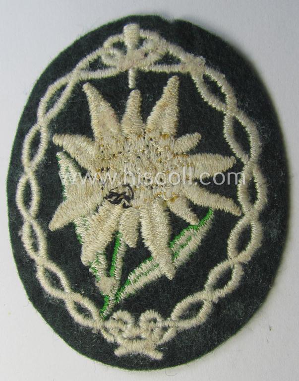 Minimally used and/or tunic-removed, WH (Heeres) EM- (ie. NCO-) type, so-called: 'Edelweiss'-armpatch being a machine-embroidered example as was executed on darker-green wool as was specifically intended for usage by the: 'Gebirgsjäger-Truppen'