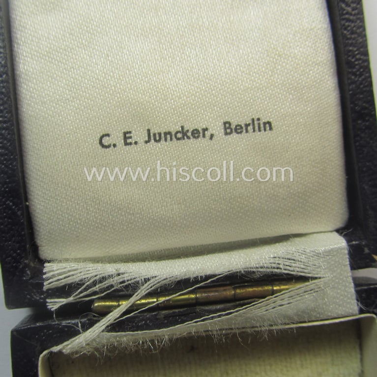 By 'C.E. Juncker-produced 'Ehrenkreuz der deutschen Mutter - erste Stufe' (or mothers'-cross in gold) that comes stored in its original and/or neatly maker- (ie. 'C.E. Juncker - Berlin'-) marked etui