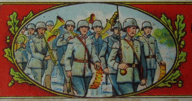 Attractive - and with certainty not that easily encountered! - TR-era- (ie. 'Deutsche Wehrmacht'-) related harmonica entitled: 'Militär-Musik' that came stored in its original, multi-coloured and/or carton-based box ie. etui