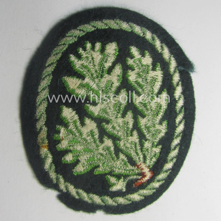 Truly used WH (Heeres) so-called: 'Jäger'-armbadge being a neatly machine-embroidered- and/or multi-coloured version as was executed on darker-green-coloured 'felt-based'-wool