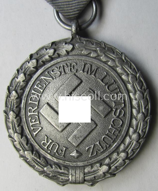 Neat, 'Luftschutz-Ehrenzeichen 2. Stufe' being a non-maker-marked example as executed in (light-weight) aluminium-based metal and that comes mounted onto its period (confectioned) ribbon ie. 'Bandabschnitt'