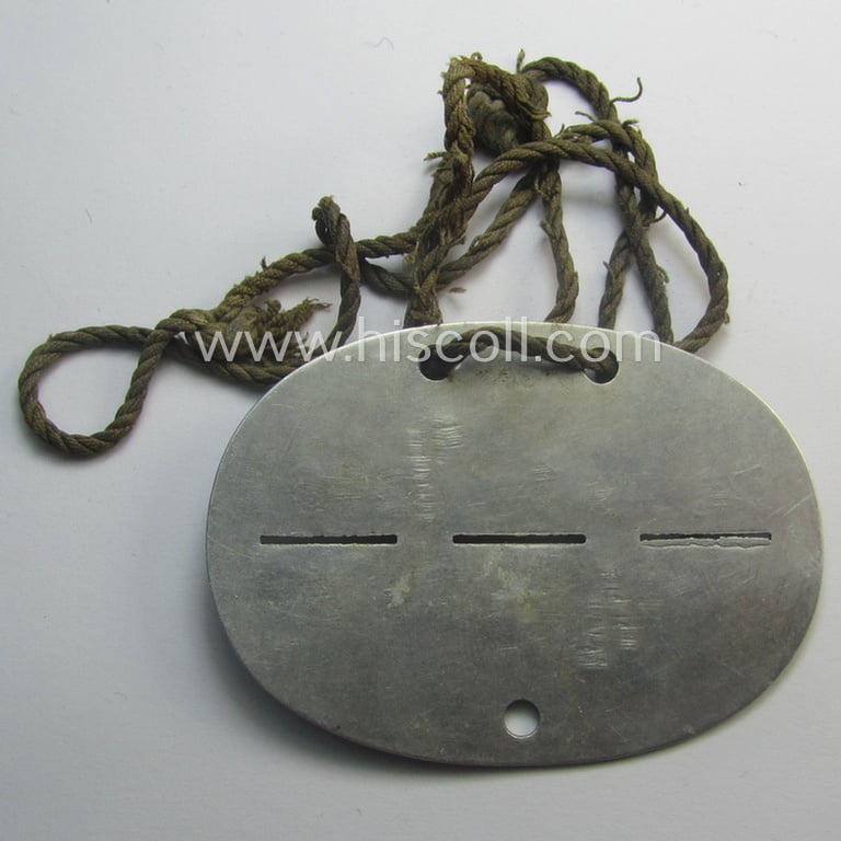 Aluminium-based, WH (Heeres) medical- (ie. 'Sanitäter'-) related ID-disc, bearing the clearly stamped unit-designation: 'Kr.Kw.Zug 1/384' and that comes mounted onto its period cord as issued and/or worn