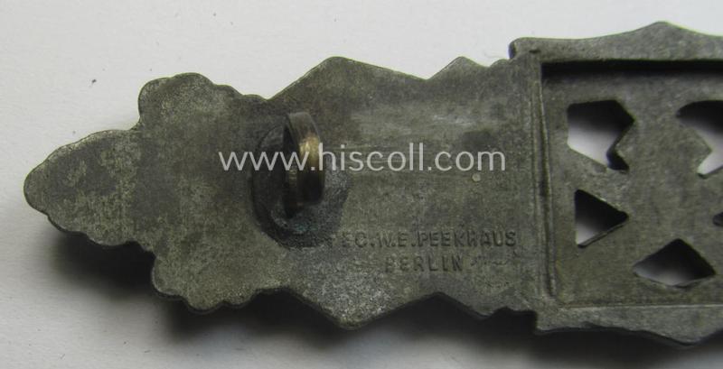 'Nahkampfspange in Bronze' (or: bronze-class close-combat clasp ie. CCC) being a maker- (ie. 'FLL'-) marked- and minimally converse-shaped so-called: '3rd pattern'-specimen as was produced by the maker- (ie. 'Hersteller') 'Friedrich Linden'