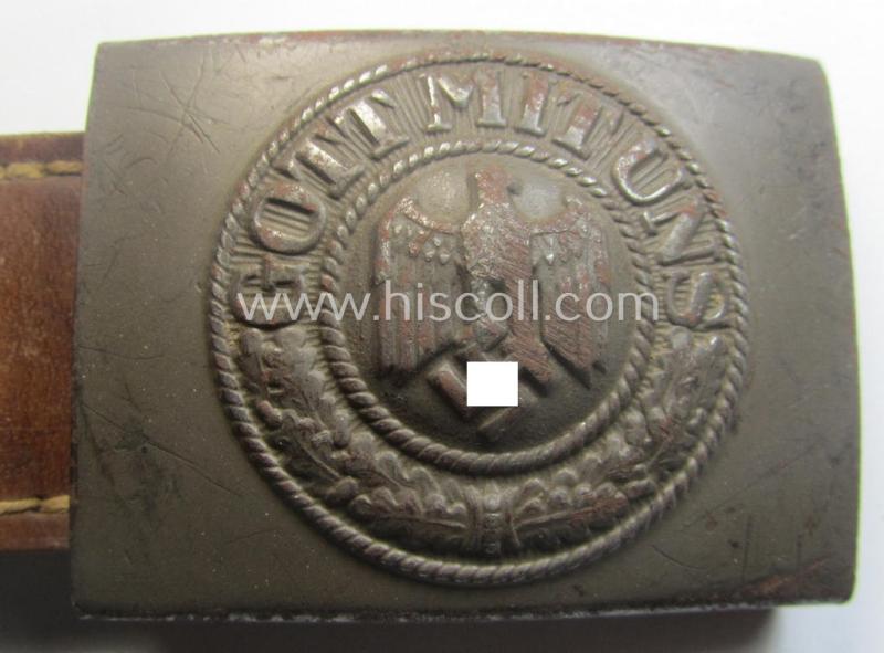 Moderately used, WH (Heeres) field-grey-coloured- and/or steel-based belt-buckle being a non-maker-marked example that comes mounted onto its maker- (ie. 'F.W. Assmann - Lüdenscheid'-) marked and/or '1940'-dated leather-based tab