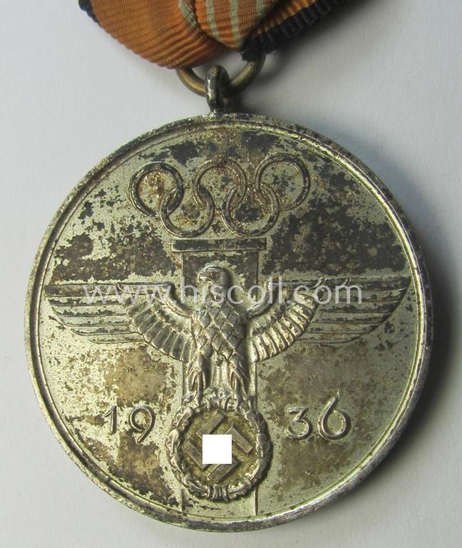 Atractive example of a: 'Deutsche Olympia-Erinnerungsmedaille 1936' being a non-maker-marked example that comes mounted onto its original (orange-red-coloured ribbon (ie. 'Bandabschnitt') as issued