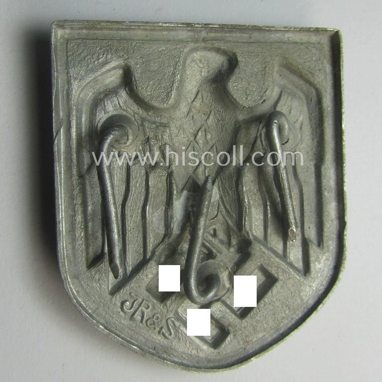 WH (Heeres) tropical- (ie. 'DAK'- or: 'Deutsches Afrikakorps'-) related- and/or aluminium-based, eagle-'pith-helmet'-shield being a maker- (ie. 'JR & S'-) marked example that comes in a very nice- (ie. hardly used-), condition