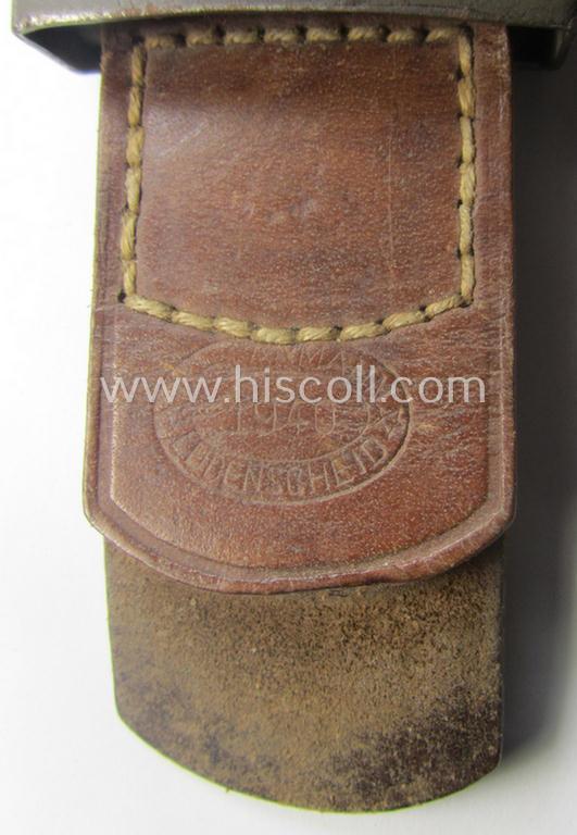 Moderately used, WH (Heeres) field-grey-coloured- and/or steel-based belt-buckle being a non-maker-marked example that comes mounted onto its maker- (ie. 'F.W. Assmann - Lüdenscheid'-) marked and/or '1940'-dated leather-based tab