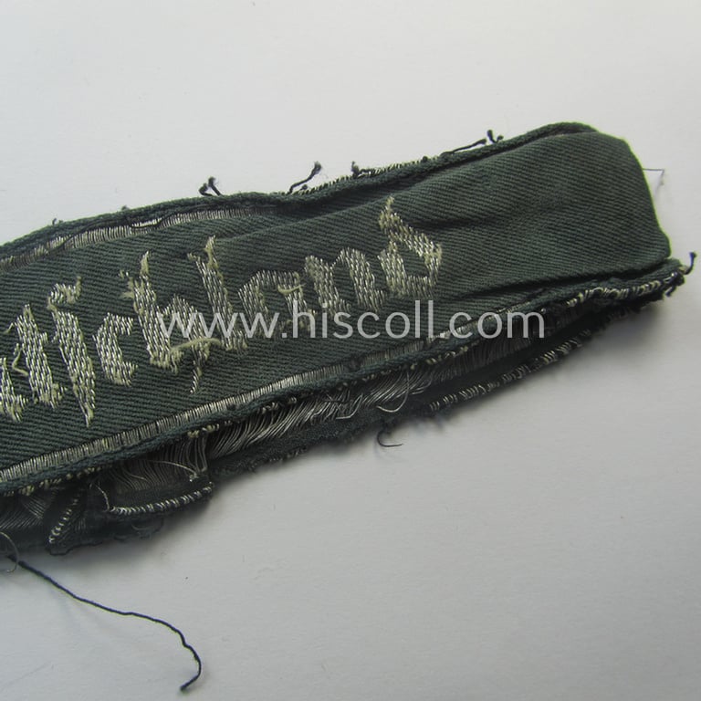 Truly worn- (ie. relic) example of the - rarely encountered! - WH (Heeres) EM- (ie. NCO-) type 'Grossdeutschland'-cuff-title (ie. Ärmelstreifen) being a shortened example of the 1st pattern (as executed in so-called: 'BeVo-flat-wire-woven'-pattern)