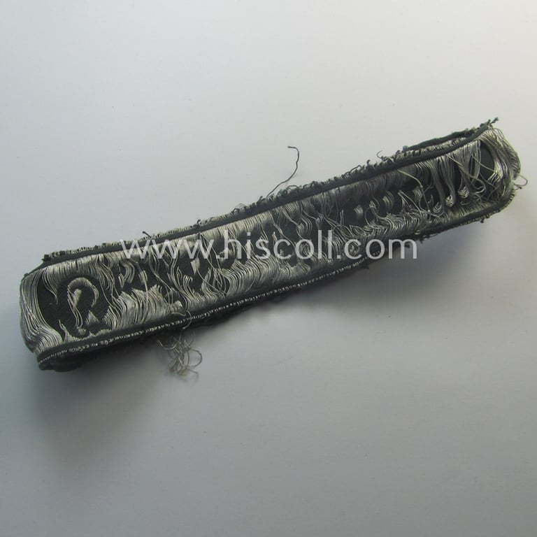 Truly worn- (ie. relic) example of the - rarely encountered! - WH (Heeres) EM- (ie. NCO-) type 'Grossdeutschland'-cuff-title (ie. Ärmelstreifen) being a shortened example of the 1st pattern (as executed in so-called: 'BeVo-flat-wire-woven'-pattern)