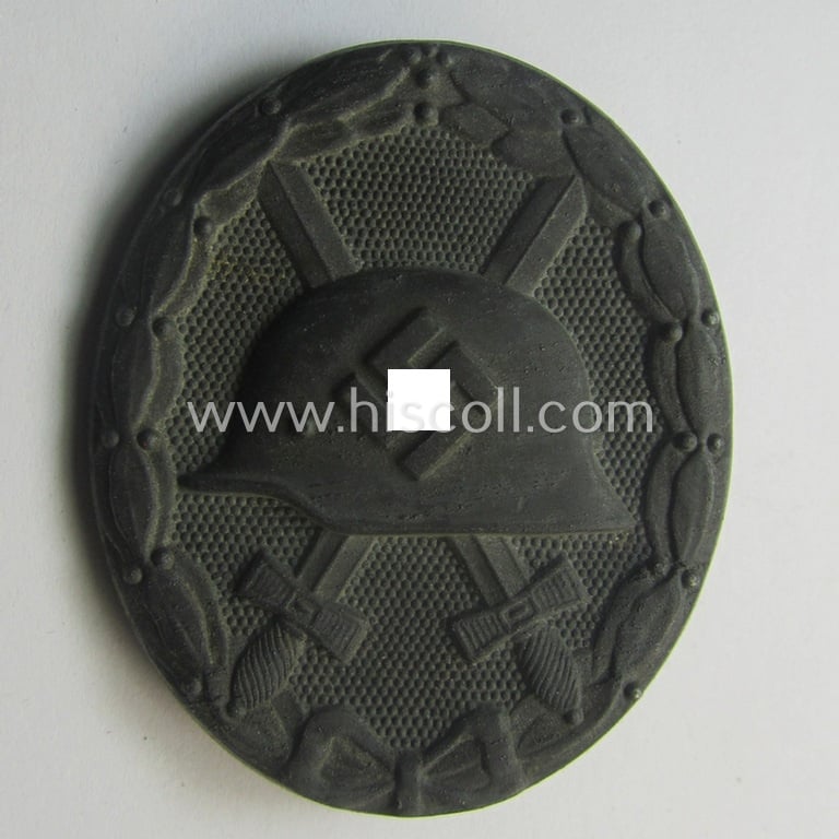 Unusual, silver-class wound-badge (or: 'Verwundeten-Abzeichen in Siber') being a maker- (ie. '127'-) marked example that comes stored in its original (damaged), carton-based pouch by the maker (ie. 'Hersteller'): 'Moriz Hausch A.-G.'