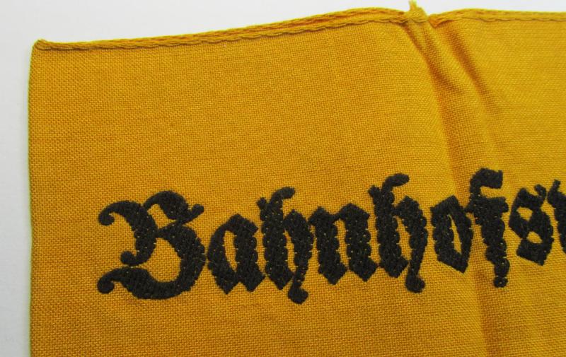 Very nice - and scarely encountered! - Wehrmacht-related, golden-yellow-coloured and/or typical linnen-based armband (ie. 'Armbinde') as executed in 'BeVo'-weave-pattern entitled: 'Bahnhofswache'