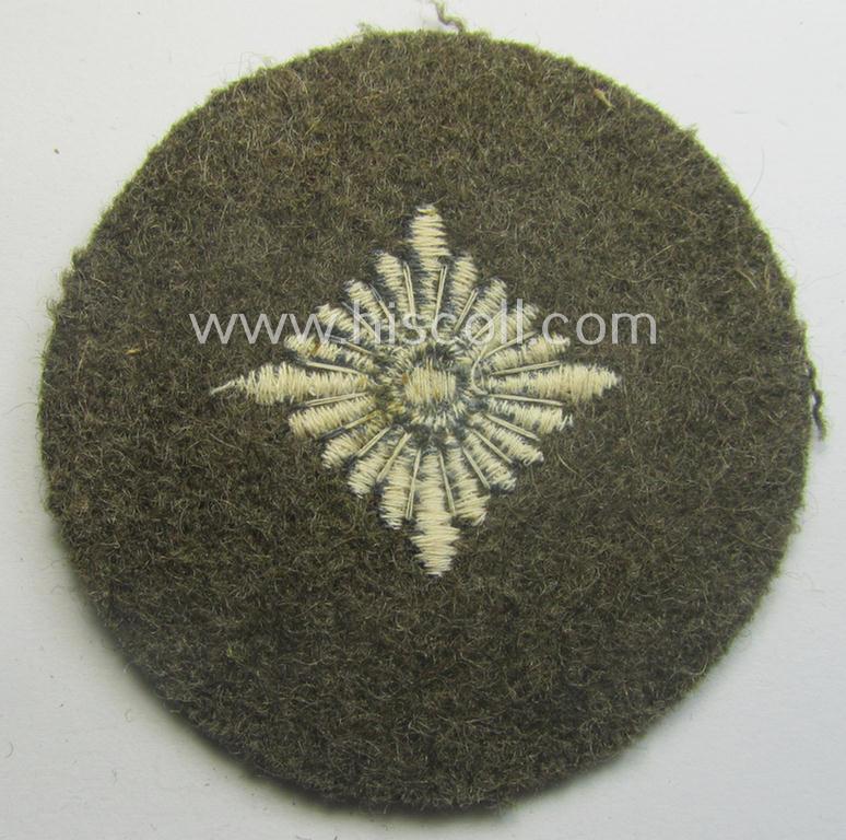 WH (Heeres) 'standard-type'- and early-pattern, tropical-style rank-insignia (ie. roundel), as executed in bluish-grey coloured linnen on a brownish-green background: 'Oberschütze'