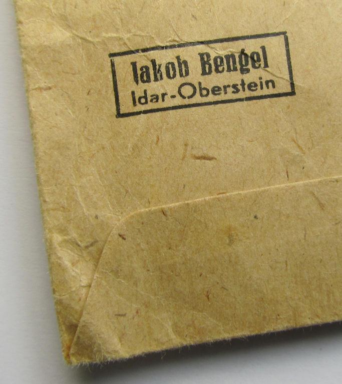 Attractive, 'Ehrenkreuz der deutschen Mutter - dritte Stufe' (or: bronze-class mothers'-cross) that came mounted onto its long-sized ribbon and that came stored in its period pouch (by the maker: 'Jakob Bengel - Idar-Oberstein')