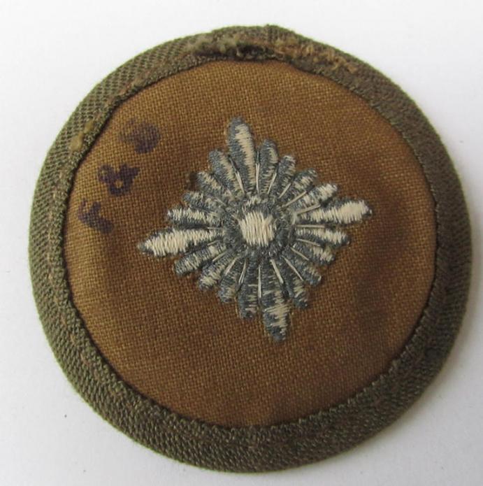 Neat, WH (Heeres) 'tropical-pattern'-, machine-embroidered rank-insignia (ie. roundel) being a neatly maker- (ie. 'F.& S.'-) marked example, as was executed in greyish-blue-coloured linnen, as was intended for an: 'Oberschütze'