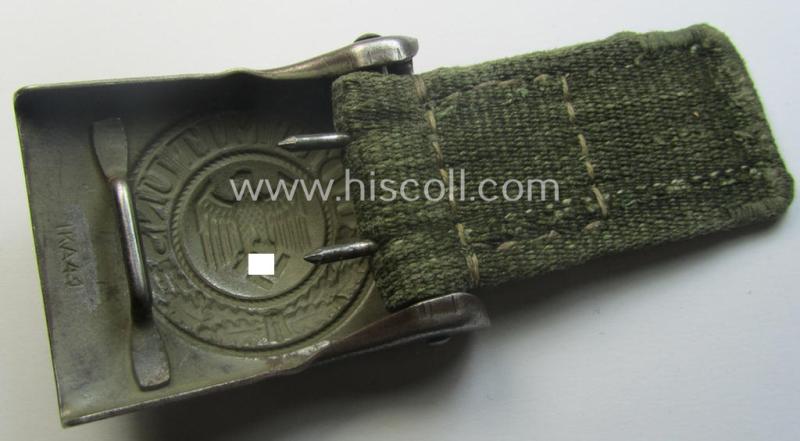 WH (Heeres) 'tropical-issued' belt-buckle being a clearly maker- (ie. 'IKA 41'-) marked, field-grey-coloured example that comes mounted onto its original, greenish-coloured- (and/or: 'webbing'-based-) tab