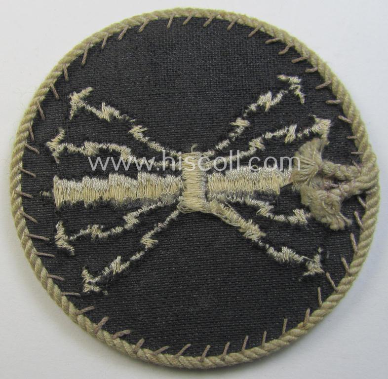 Attractive - and hardly used! - example of a WH (Luftwaffe) machine-embroidered, trade- ie. special-career-patch (ie. 'Tätigkeitsabzeichen') having a silverish-grey-toned 'Kordel' attached as was intended for: 'LW-Funk-Unteroffiziere'