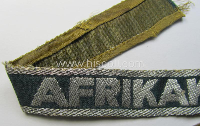 Attractive, 'BeVo'-like cuff-title (ie. 'Ärmelstreifen') entitled: 'Afrikakorps' being a with certainty issued and truly worn example that comes in an overall nice- (ie. minimally shortened- and/or once tunic-attached-), condition