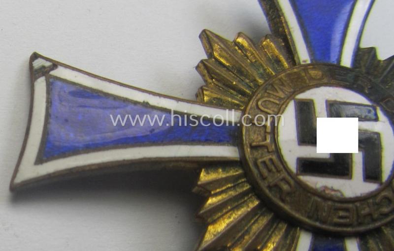 Regrettably damaged (ie. relic) 'Ehrenkreuz der deutschen Mutter - dritte Stufe' (or: bronze-class mothers'-cross) being a non-maker-marked example that comes mounted onto a (period-attached) 'clasp'