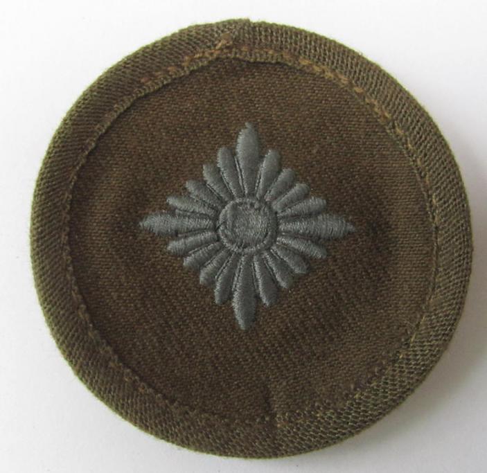 Neat, WH (Heeres) 'tropical-pattern'-, machine-embroidered rank-insignia (ie. roundel) being a neatly maker- (ie. 'F.& S.'-) marked example, as was executed in greyish-blue-coloured linnen, as was intended for an: 'Oberschütze'