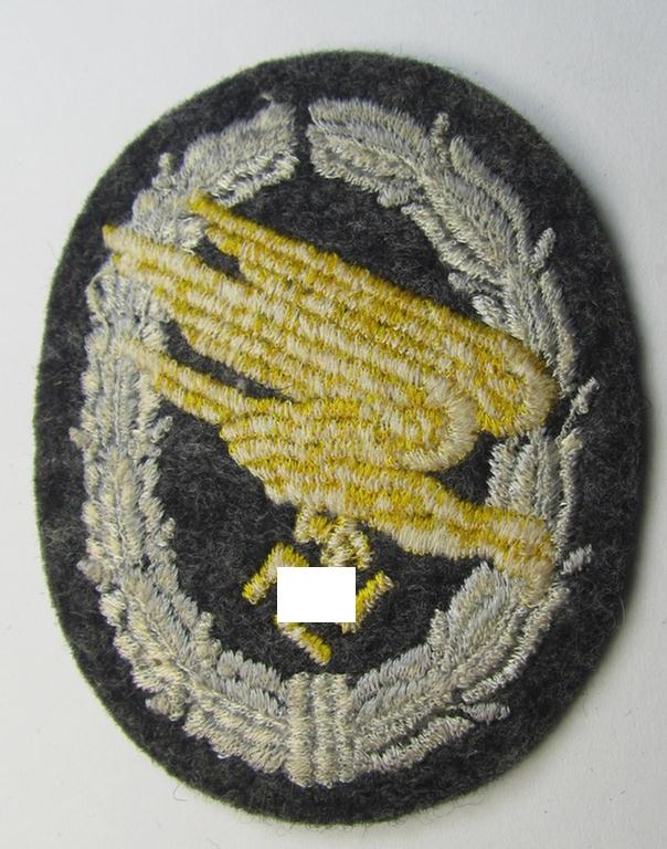 Attractive, WH (Luftwaffe) 'Fallschirmschützen-Abzeichen in Stoff' (or: cloth-based paratroopers'-jump-badge) being a nicely machine-embroidered specimen that comes in a probably issued albeit never used- ie. 'virtually mint', condition