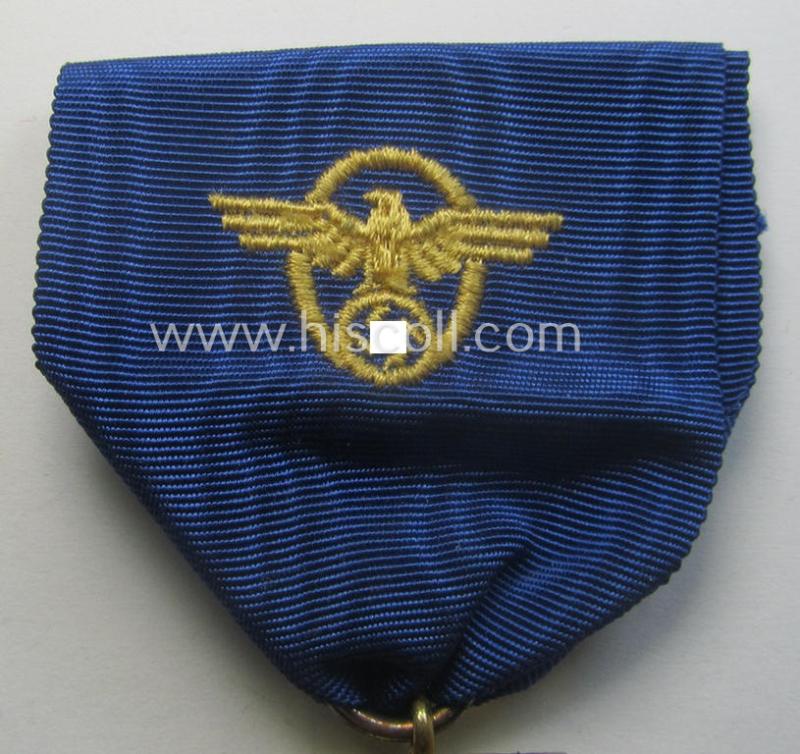 Golden-class 'Pol.-Dienstauszeichnung 1. Stufe' (or: police loyal-service medal first-class) that comes mounted onto its (typically broader-shaped) ribbon (ie. 'Bandabschnitt')