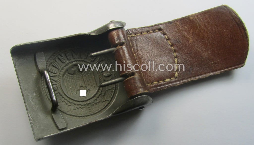 WH (Heeres) field-grey-coloured- and/or steel-based belt-buckle, being a maker- (ie. 'J. C. Maedicke'-) marked- and/or: '1941'-dated example that comes mounted on its leather-based tab and that comes in a moderately used- ie. worn, condition