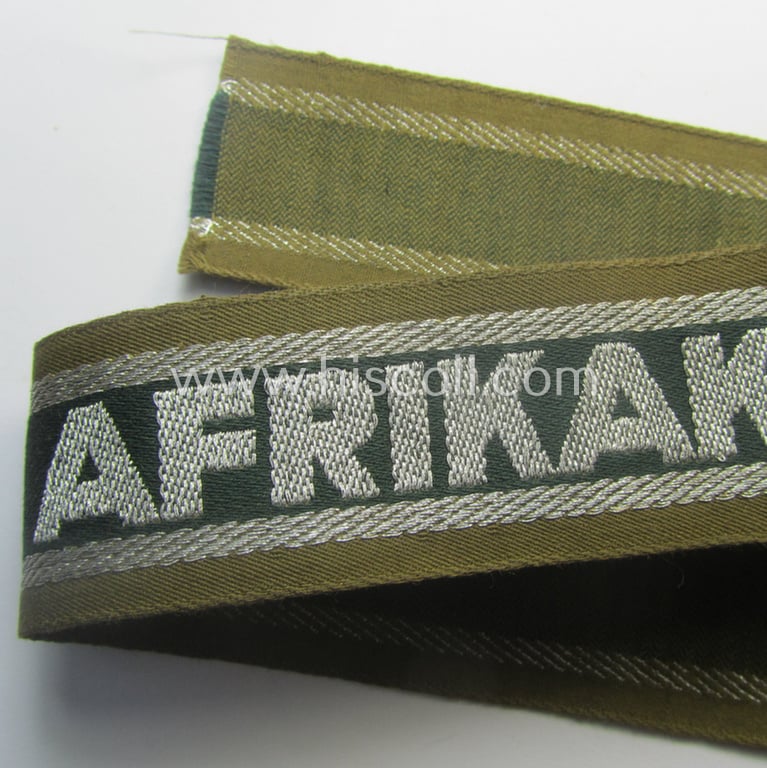 'BeVo'-like cuff-title (ie. 'Ärmelstreifen') entitled: 'Afrikakorps' being a presumably issued but simply never worn example that comes in an overall very nice- (ie. non-shortened- and never tunic-attached-), condition