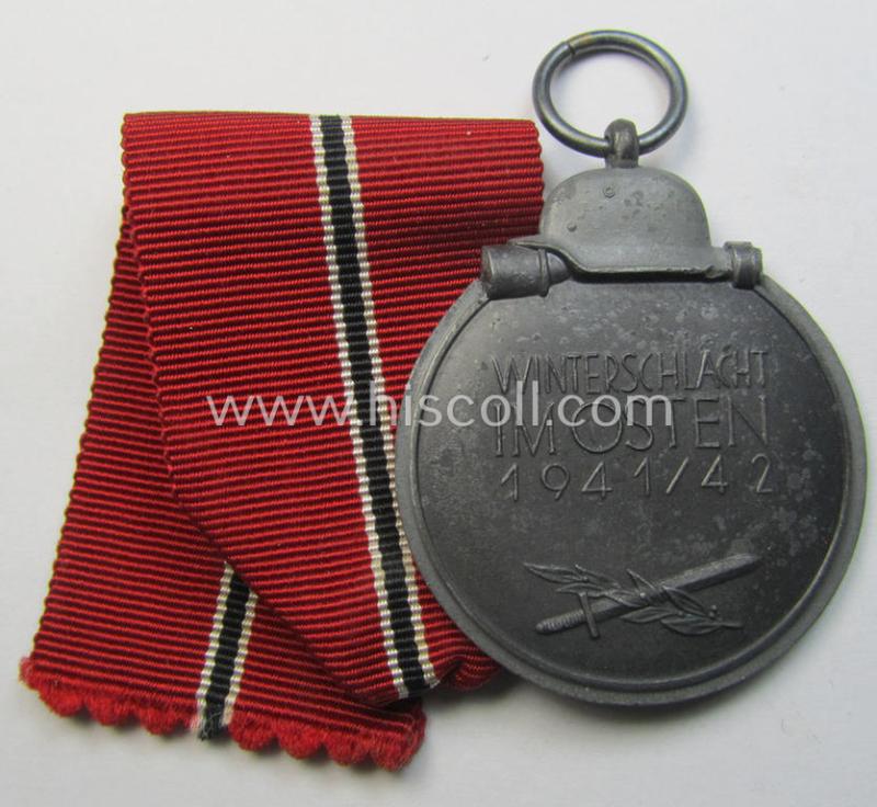 Attractive medal-set: 'Winterschlacht im Osten 1941-42' being a maker- (ie. '6.'-) marked- (and/or 'Feinzink'-based) specimen by the maker: 'Fritz Zimmermann' and that comes together with its (minimally confectioned) ribbon (ie. 'Bandabschni...