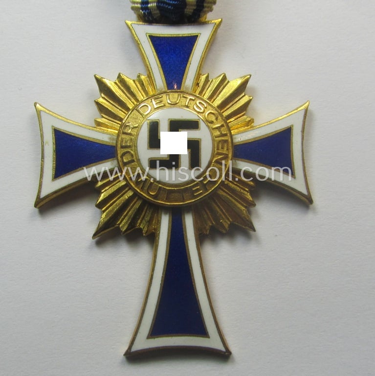 By 'C.E. Juncker-produced 'Ehrenkreuz der deutschen Mutter - erste Stufe' (or mothers'-cross in gold) that comes stored in its original and/or neatly maker- (ie. 'C.E. Juncker - Berlin'-) marked etui